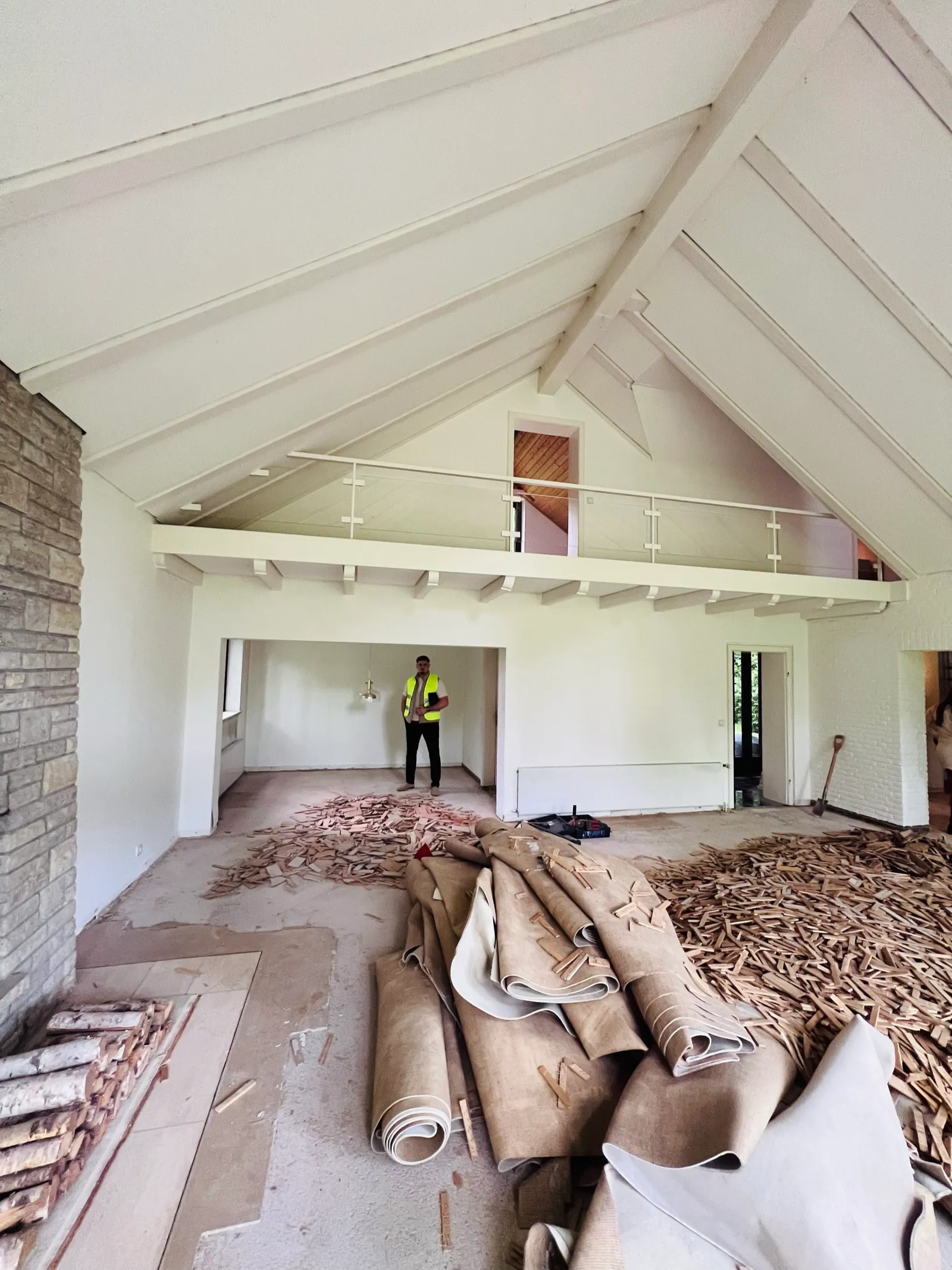 Großer Wohnraum mit hoher Decke, alte Teppich- und Parkettböden werden entfernt