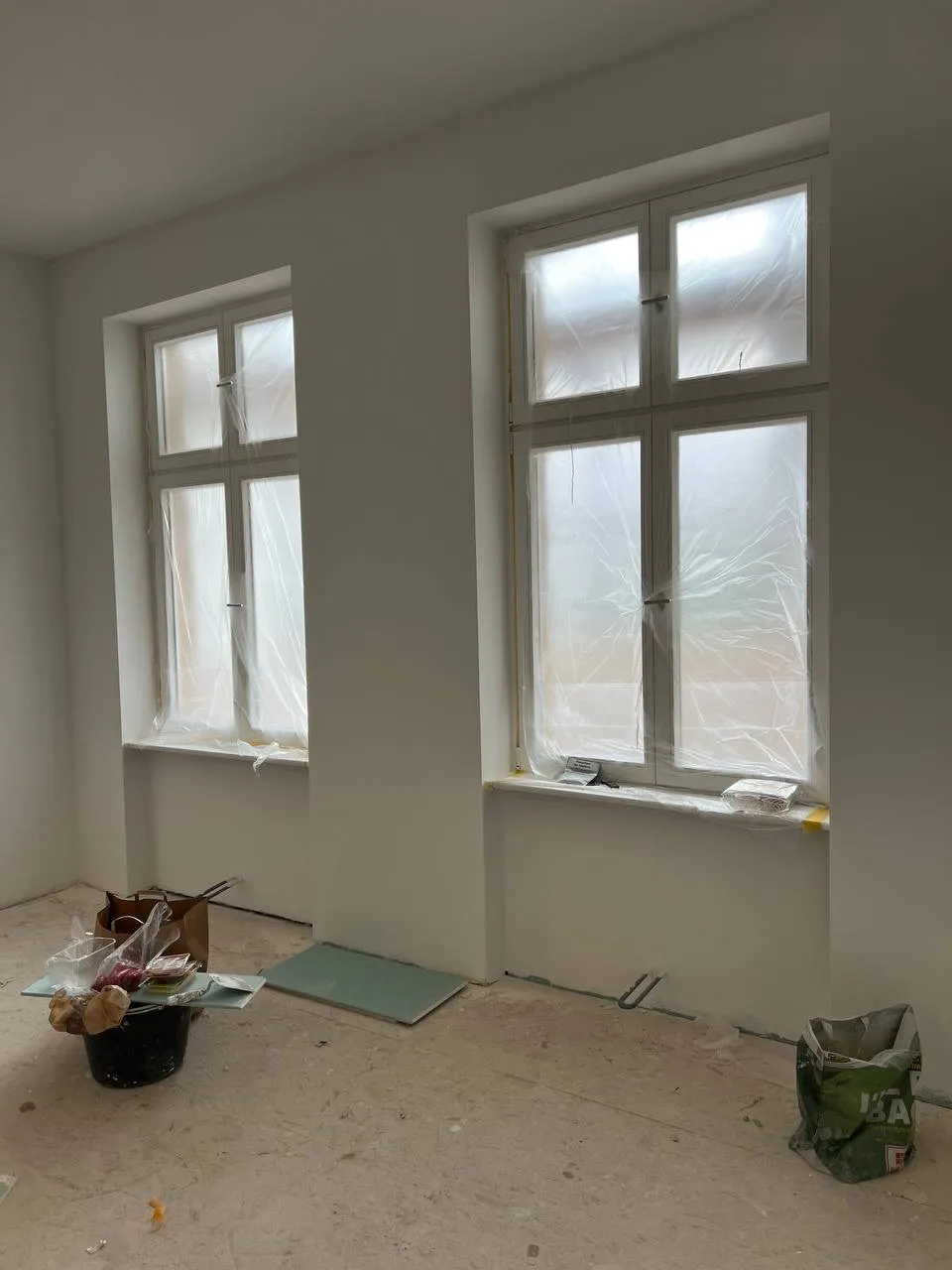 Fenster geschützt, Wände gespachtelt — Ordnung während der Arbeit.
